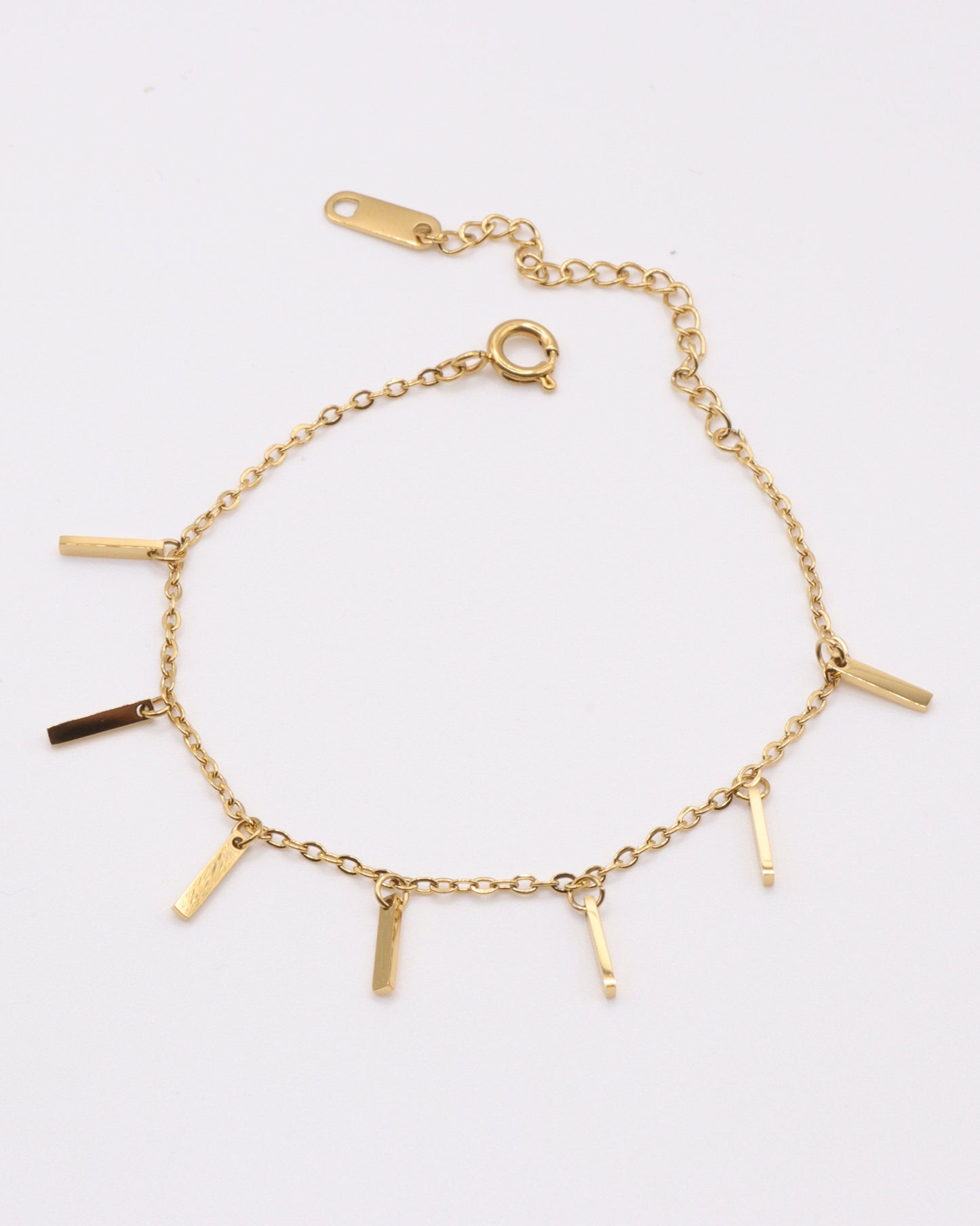 photo bracelet bâtonnets doré sur fond gris clair