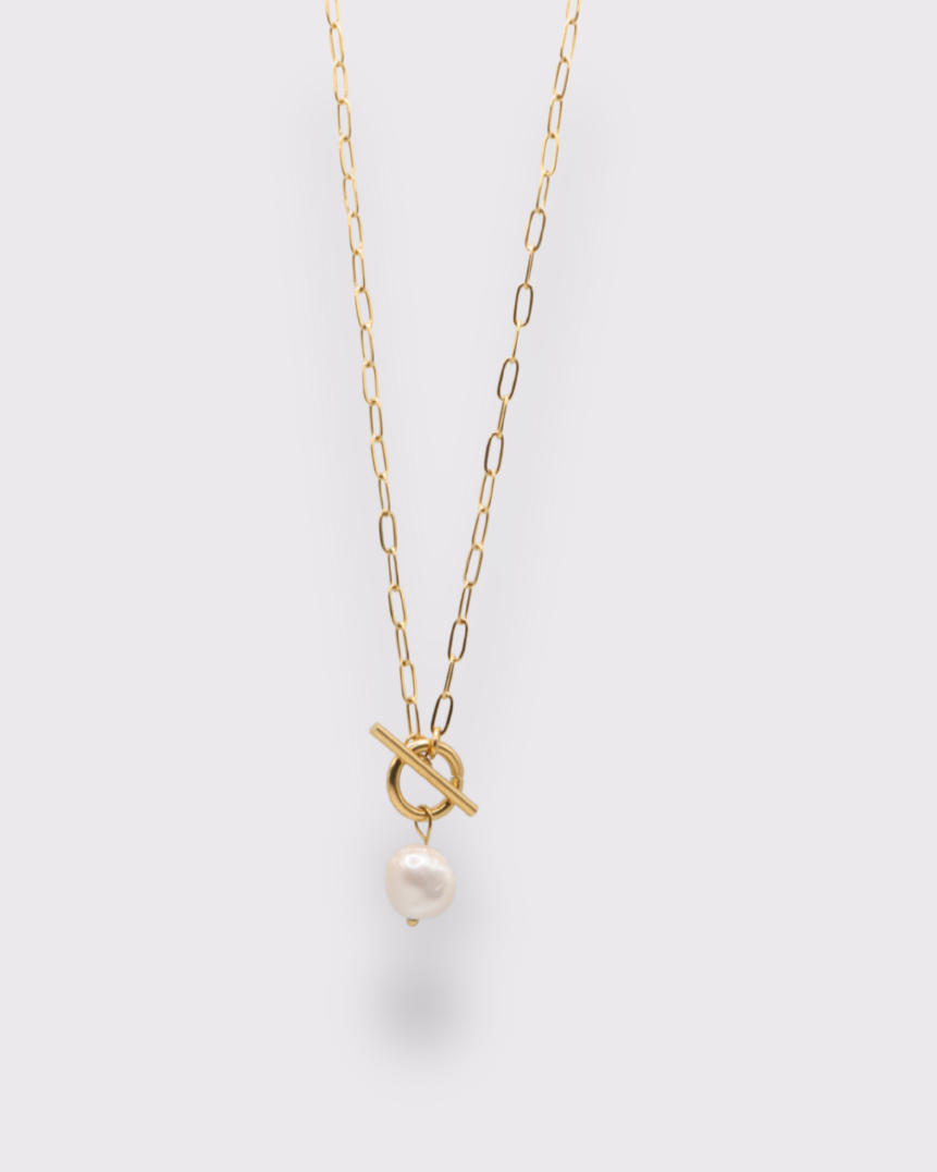 collier perle et bascule en acier inoxydable doré à l'or 750/1000ème sur fond gris clair