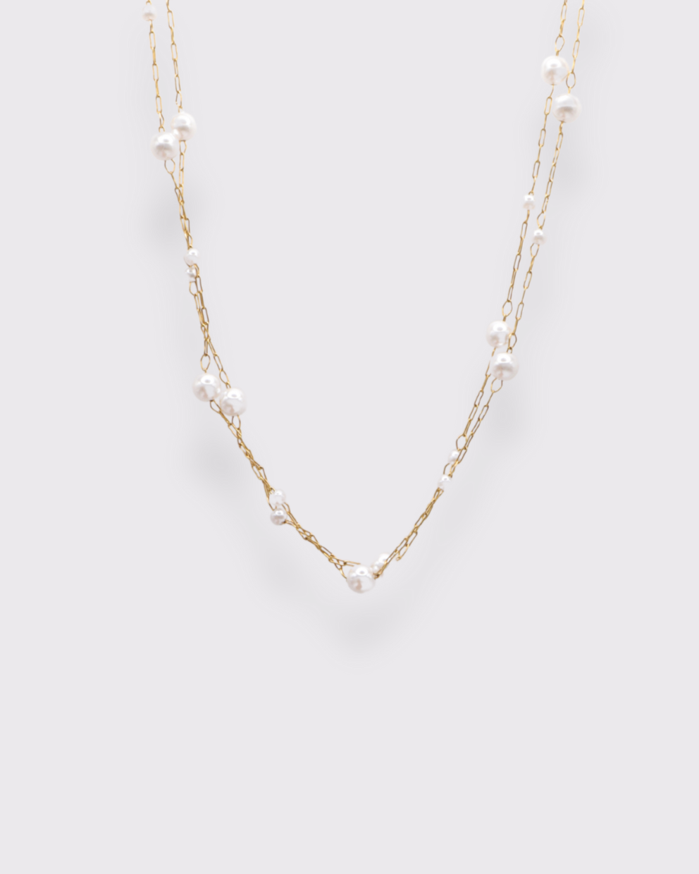 Photo du collier de perles superposée en acier inoxydable doré à l'or 750/1000ème (18 carats) et perles d'eau douce sur fond gris clzir