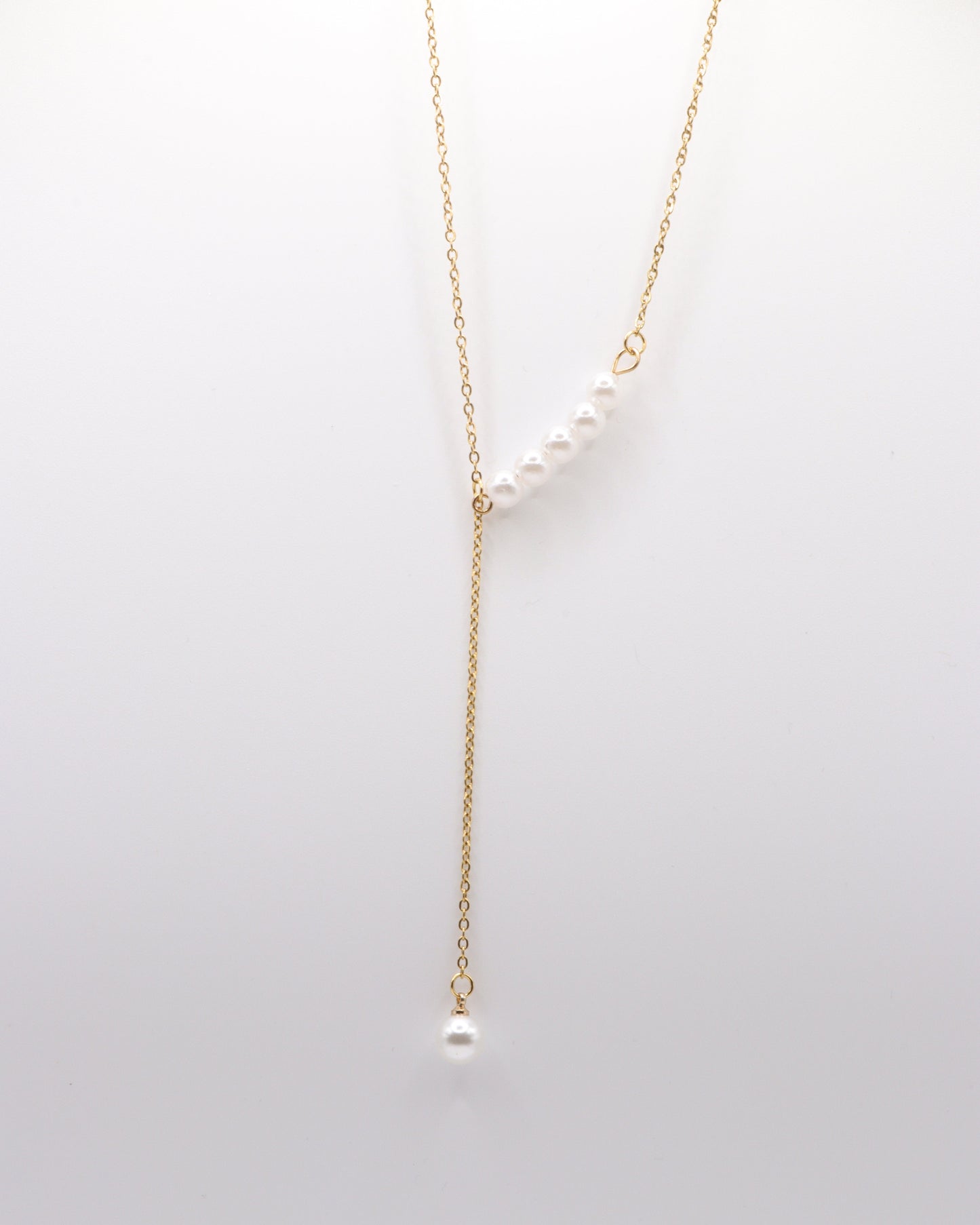 photo collier y perles doré fond gris