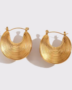 photo des boucles d'oreilles ethniques doré à l'or 750/1000ème (18 carats) sur fond gris clair