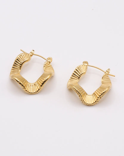 photo des boucles d'oreilles créoles ondulées en doré à l'or 750/1000èeme (18 carats) sur fond gris clair