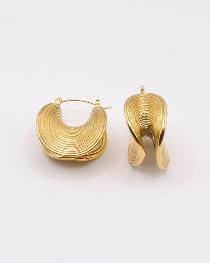 photo des boucles d'oreilles ethniques doré à l'or 750/1000ème (18 carats) sur fond gris clair