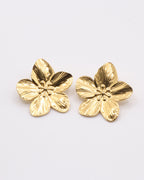 photo des boucles d'oreilles fleur sur fond gris clair