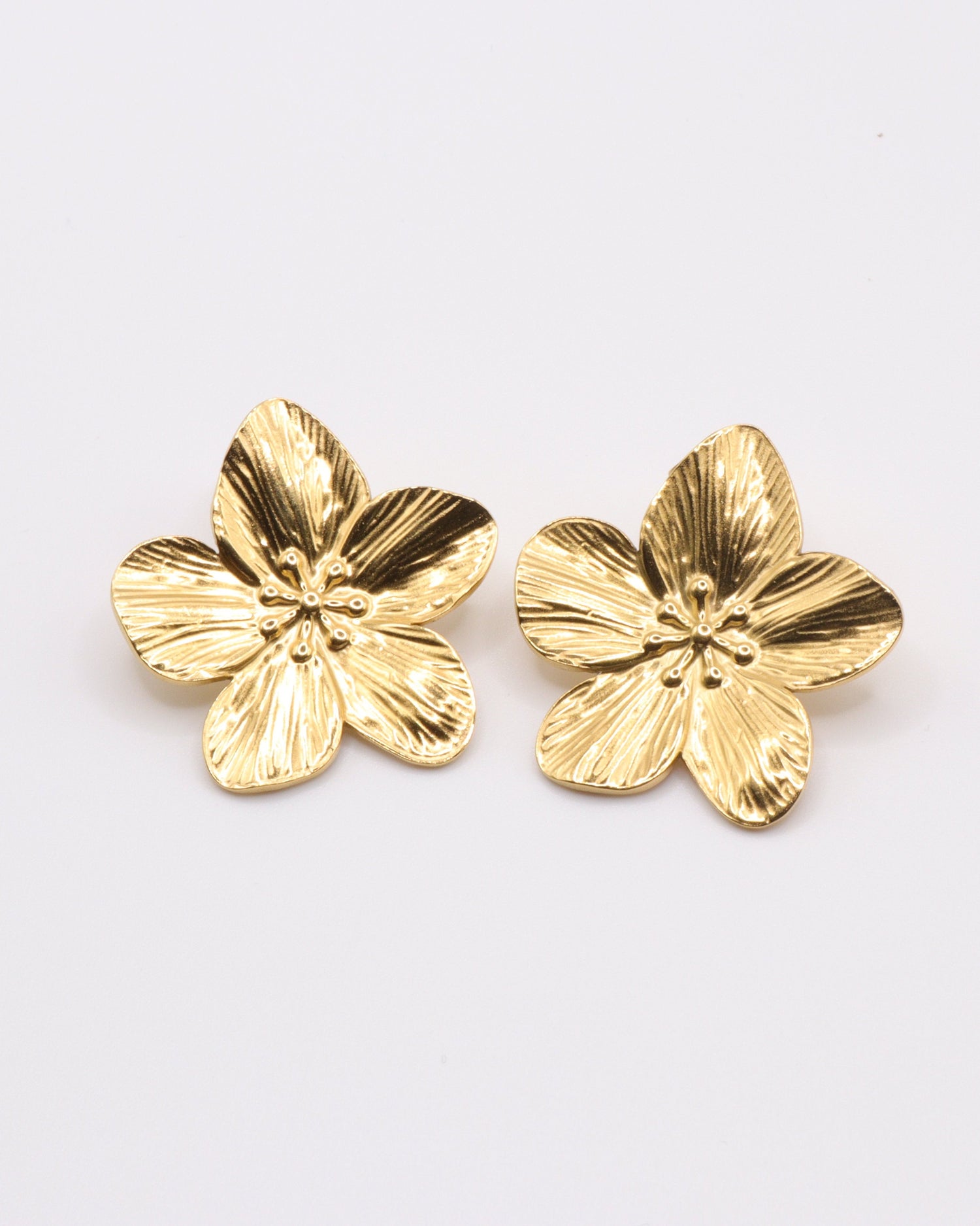 photo des boucles d'oreilles fleur sur fond gris clair