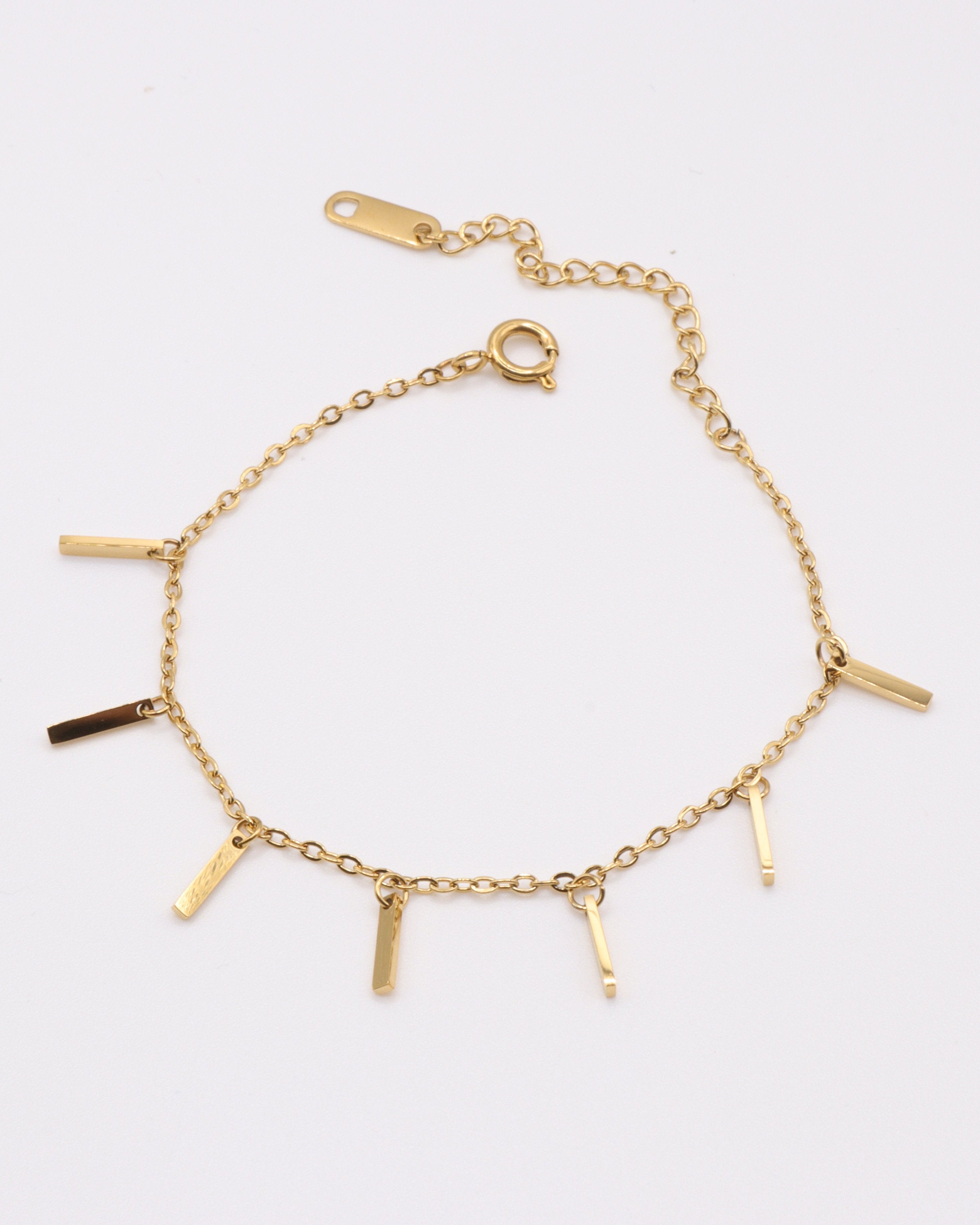 photo bracelet bâtonnets doré sur fond gris clair