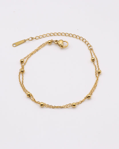Photo du bracelet double à maille satelite en acier inoxydable doré à l'or 750/1000ème (18 carats) sur fond gris clair