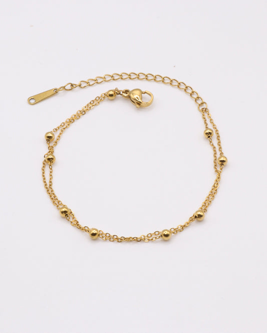 Photo du bracelet double à maille satelite en acier inoxydable doré à l'or 750/1000ème (18 carats) sur fond gris clair