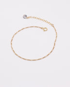 Photo du bracelet figaro et zirconium en acier inoxydable doré à l'or 750/1000ème (18 carats) sur fond gris clair