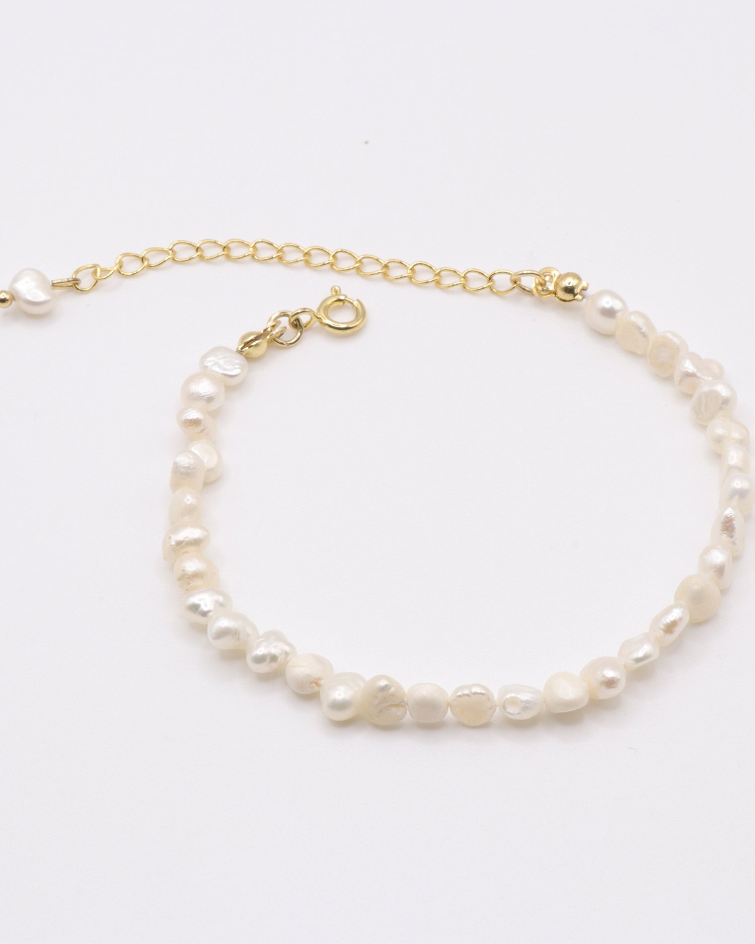 Photo du bracelet à petite perles d'eau douce doré à l'or 750/1000ème (18 carats) sur fond gris clair