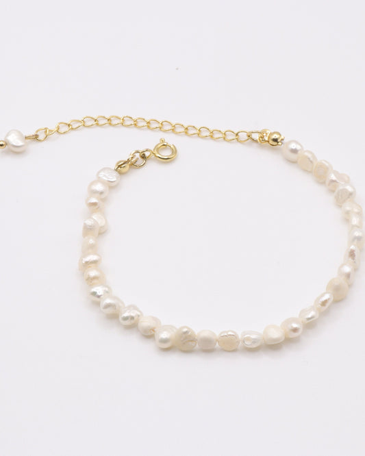 Photo du bracelet à petite perles d'eau douce doré à l'or 750/1000ème (18 carats) sur fond gris clair