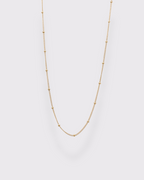 Photo du collier ras du cou à maille petit satéllite en acier inoxydable doré à l'or 750/1000ème (18 carats) sur fond gris clair 