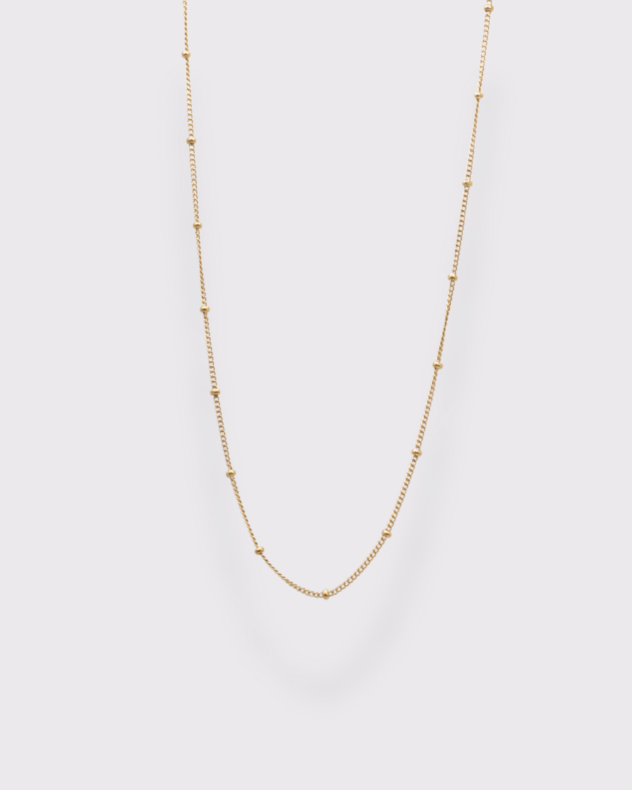 Photo du collier ras du cou à maille petit satéllite en acier inoxydable doré à l'or 750/1000ème (18 carats) sur fond gris clair 