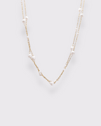Photo du collier de perles superposée en acier inoxydable doré à l'or 750/1000ème (18 carats) et perles d'eau douce sur fond gris clzir