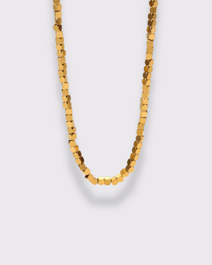 photo du collier petits carrés en doré à l'or 750/1000ème (18 carats) sur fond gris clair