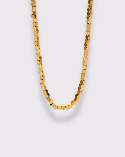 photo du collier petits carrés en doré à l'or 750/1000ème (18 carats) sur fond gris clair