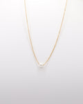 photo collier chocker une perle sur fond gris clair