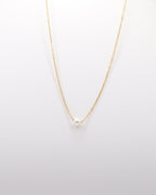 photo collier chocker une perle sur fond gris clair