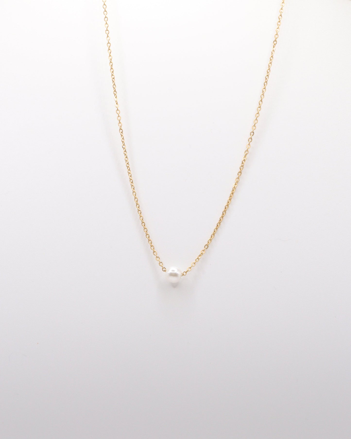 photo collier chocker une perle sur fond gris clair
