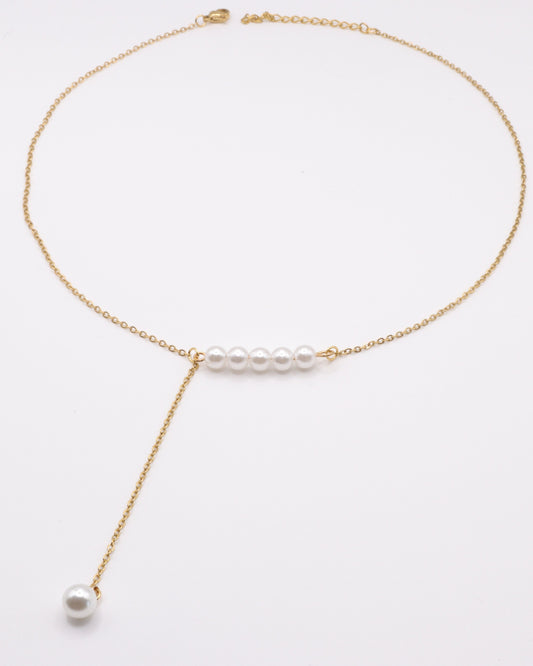 photo collier y perles doré fond gris 